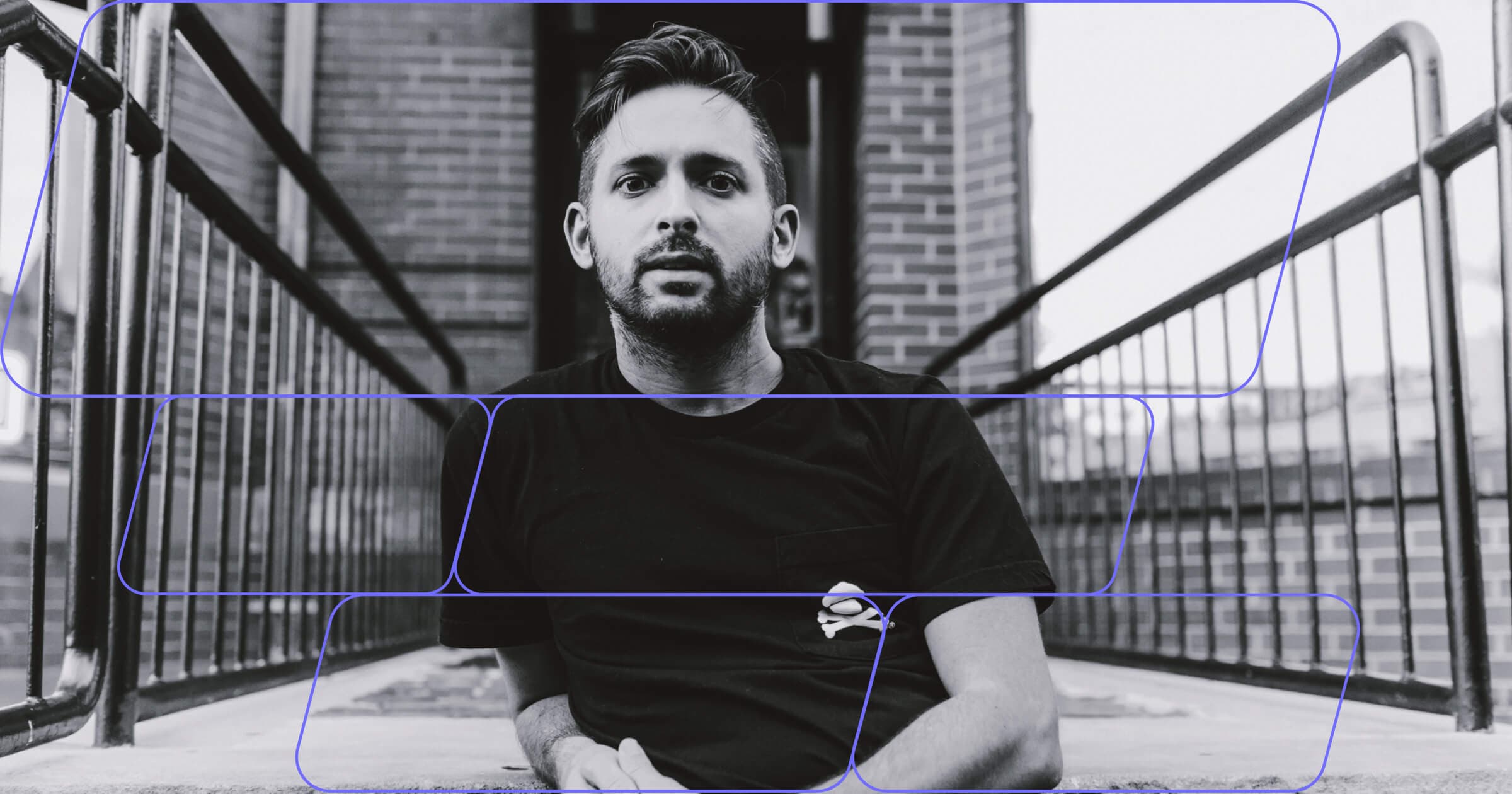 Black-and-white portrait of a man with a Johnny Cupcakes branded shirt standing on an outdoor walkway, overlaid with geometric line graphics.