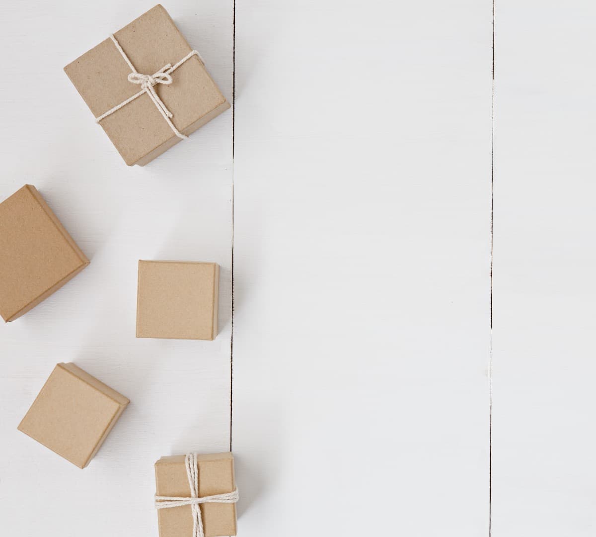 Five brown boxes, two of which are tied with twine, on a white background.